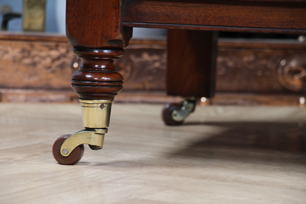 A three-tier Victorian walnut dumb waiter featuring turned columns, carved pediment gallery, two central drawers with brass handles, and brass castors. View XIX