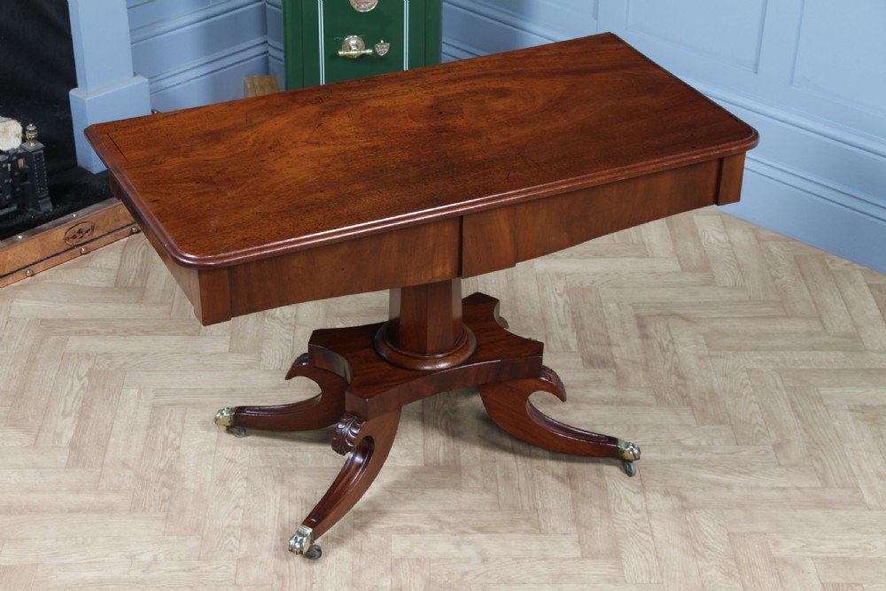 A Regency period mahogany centre table featuring a rectangular top with rounded corners on a central octagonal column and quadform platform base with swept legs. View II