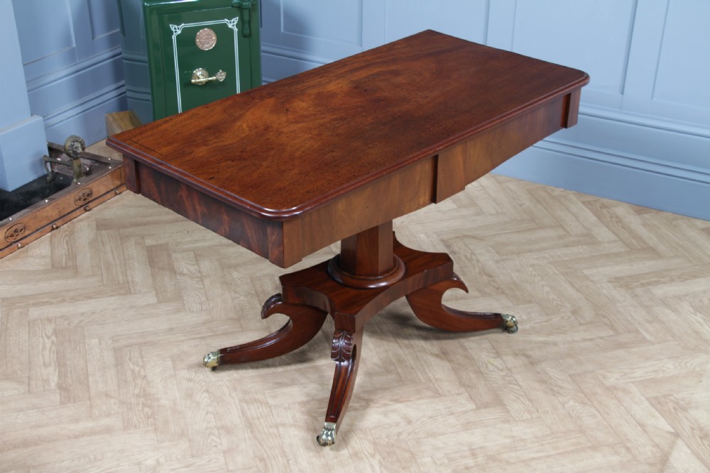 A Regency period mahogany centre table featuring a rectangular top with rounded corners on a central octagonal column and quadform platform base with swept legs. View V