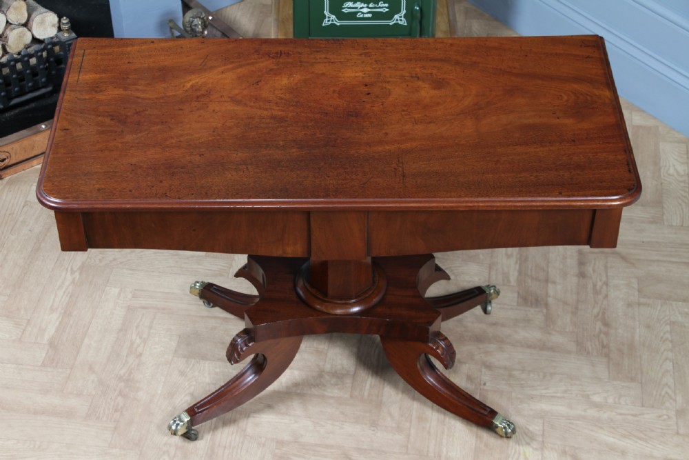 A Regency period mahogany centre table featuring a rectangular top with rounded corners on a central octagonal column and quadform platform base with swept legs. View VIII