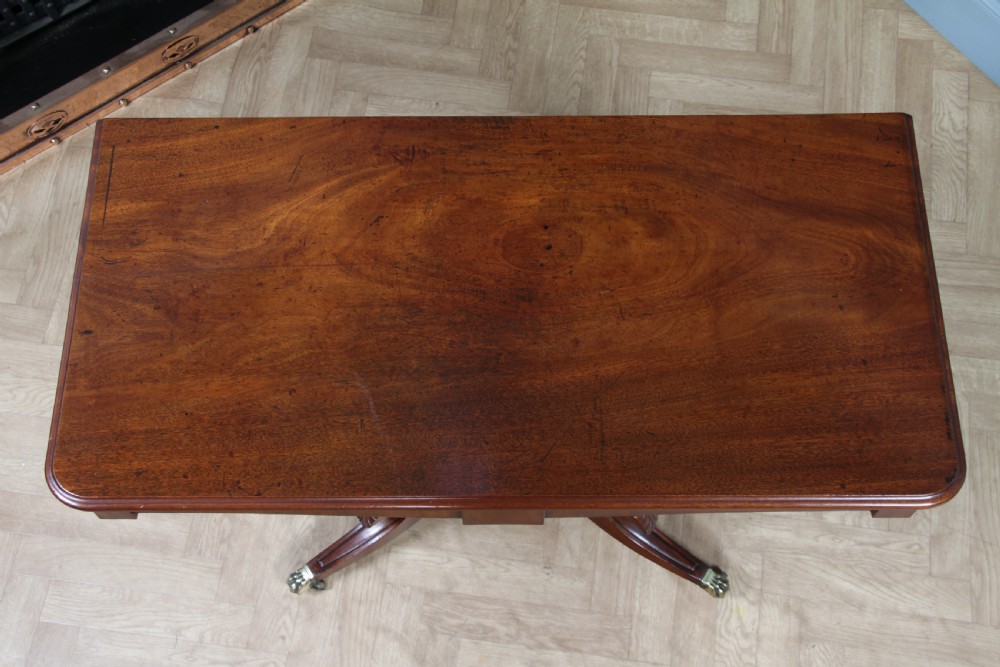 A Regency period mahogany centre table featuring a rectangular top with rounded corners on a central octagonal column and quadform platform base with swept legs. View XI