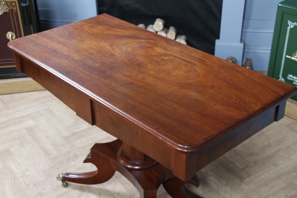 A Regency period mahogany centre table featuring a rectangular top with rounded corners on a central octagonal column and quadform platform base with swept legs. View XII