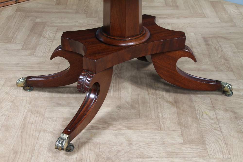 A Regency period mahogany centre table featuring a rectangular top with rounded corners on a central octagonal column and quadform platform base with swept legs. View XIII