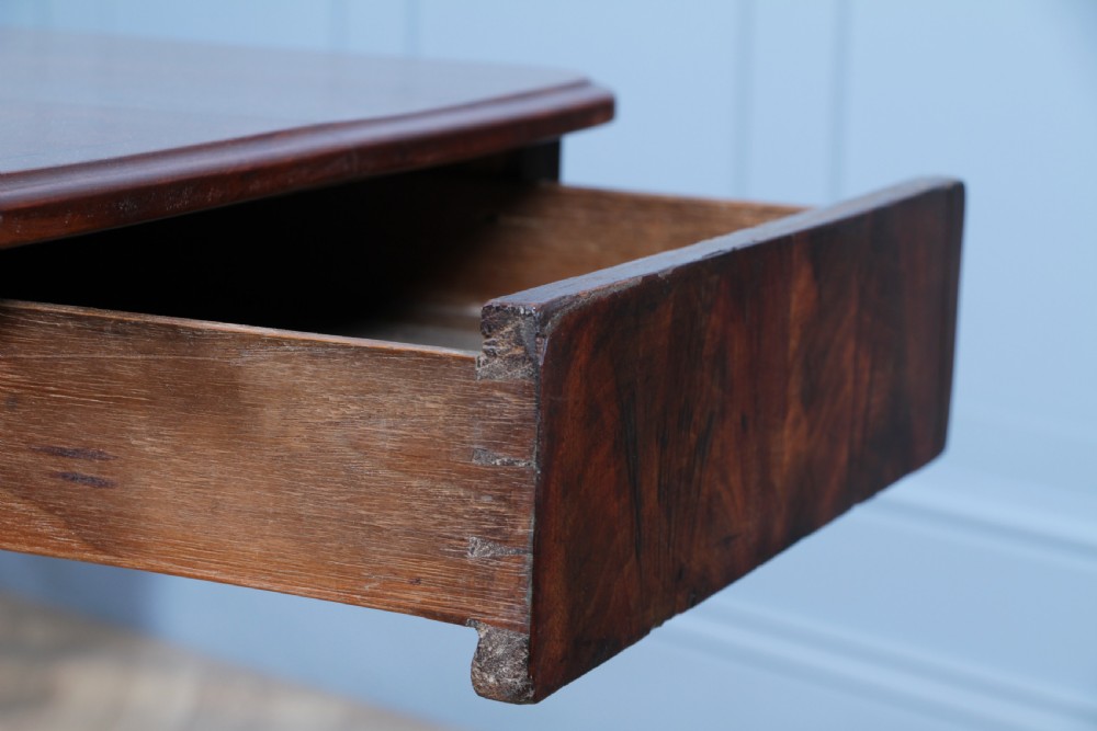 A Regency period mahogany centre table featuring a rectangular top with rounded corners on a central octagonal column and quadform platform base with swept legs. View XVII