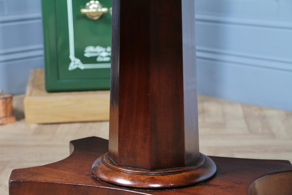 A Regency period mahogany centre table featuring a rectangular top with rounded corners on a central octagonal column and quadform platform base with swept legs. View XVIII