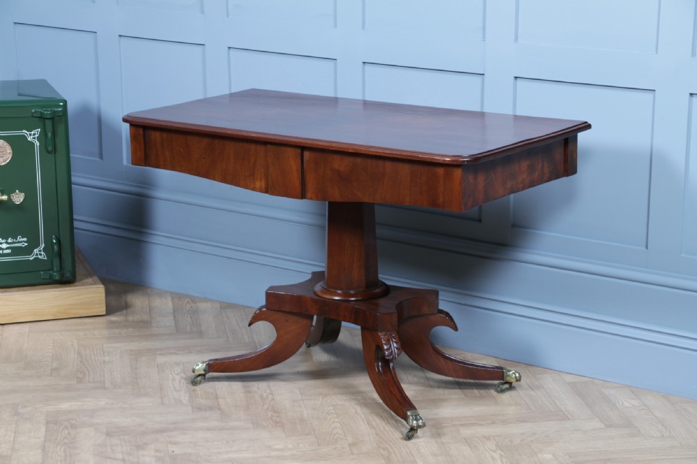 A Regency period mahogany centre table featuring a rectangular top with rounded corners on a central octagonal column and quadform platform base with swept legs. View XXII