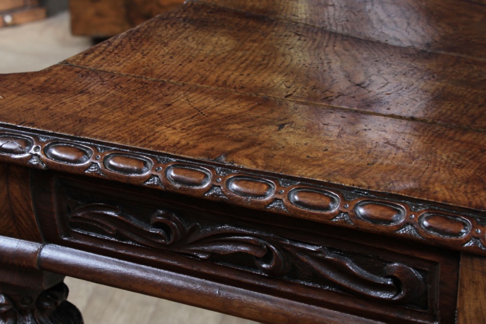 An antique carved dark oak hall chair featuring a decorative backrest with a central crest motif, finials, and barley twist front legs. View XIX