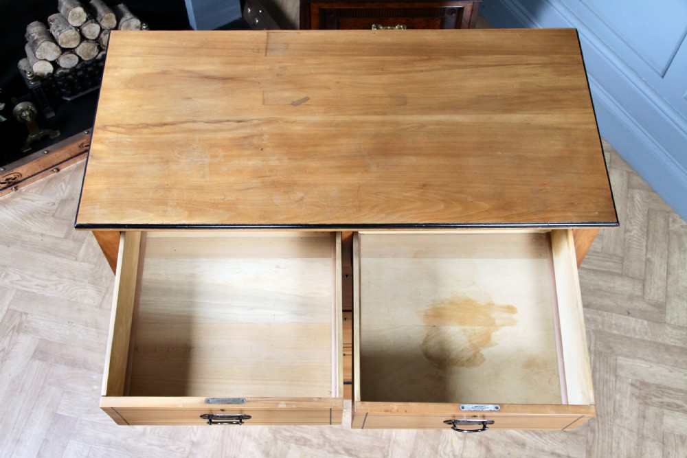A late Victorian satinwood chest featuring two short drawers above three long drawers with ebonised stringing and dark metal handles on a solid plinth base. View XVI