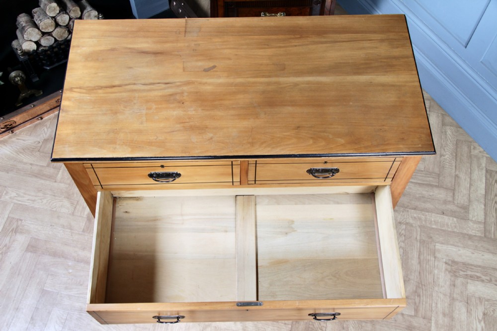 A late Victorian satinwood chest featuring two short drawers above three long drawers with ebonised stringing and dark metal handles on a solid plinth base. View XVII