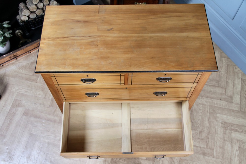 A late Victorian satinwood chest featuring two short drawers above three long drawers with ebonised stringing and dark metal handles on a solid plinth base. View XVIII