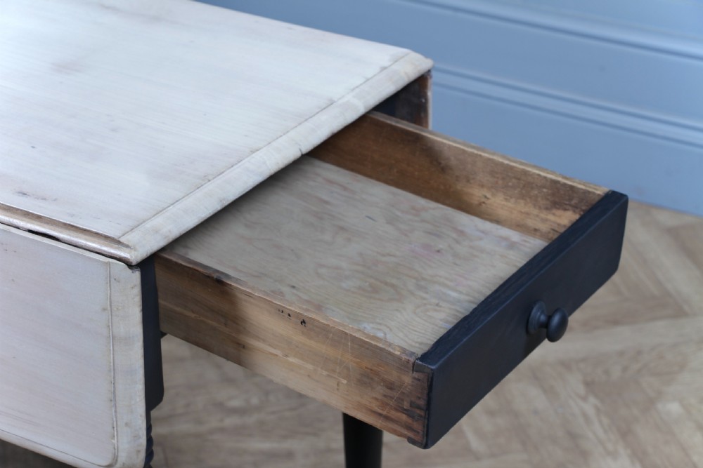 A restored Victorian Pembroke table featuring a bleached mahogany drop-leaf top and a black painted frame with turned legs on brass castors. View XIII
