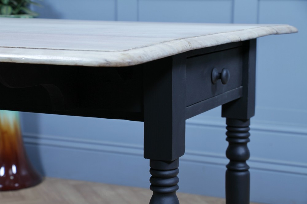 A restored Victorian Pembroke table featuring a bleached mahogany drop-leaf top and a black painted frame with turned legs on brass castors. View XV