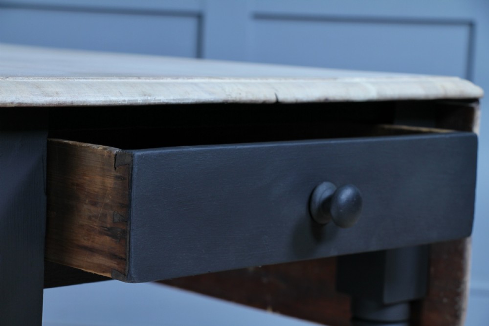A restored Victorian Pembroke table featuring a bleached mahogany drop-leaf top and a black painted frame with turned legs on brass castors. View XVIII