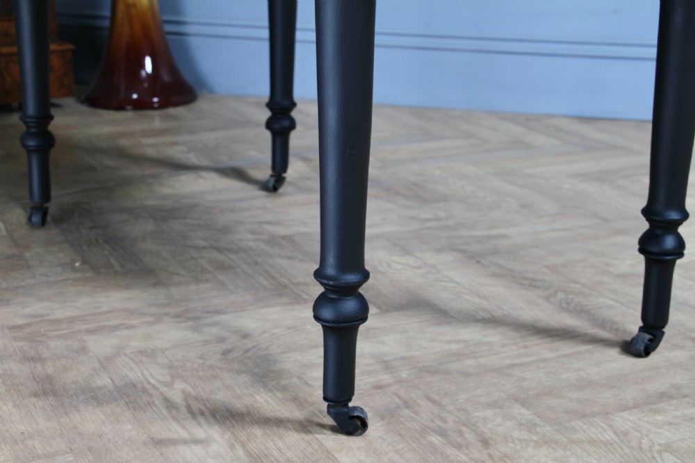 A restored Victorian Pembroke table featuring a bleached mahogany drop-leaf top and a black painted frame with turned legs on brass castors. View XIX