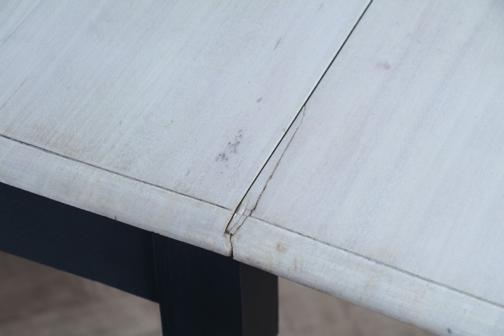 A restored Victorian Pembroke table featuring a bleached mahogany drop-leaf top and a black painted frame with turned legs on brass castors. View XXIII