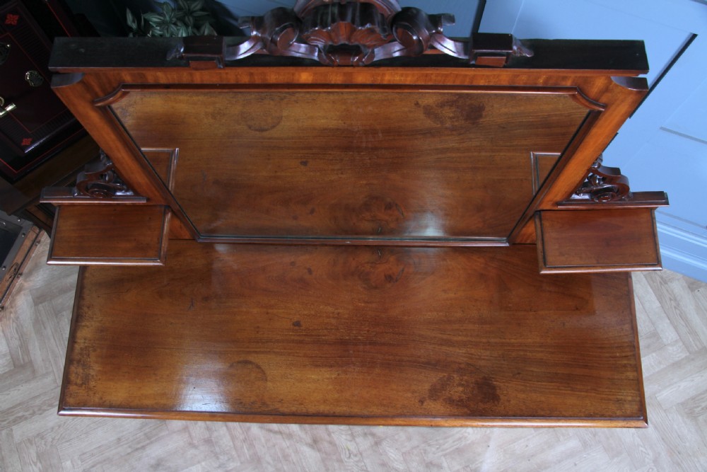 A Victorian mahogany mirror-back sideboard featuring two panelled cabinet doors, upper drawers, tiered side shelves, and a decorative carved cresting. View VIII