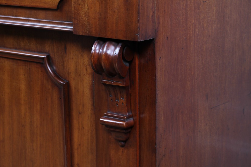 A Victorian mahogany mirror-back sideboard featuring two panelled cabinet doors, upper drawers, tiered side shelves, and a decorative carved cresting. View XIV