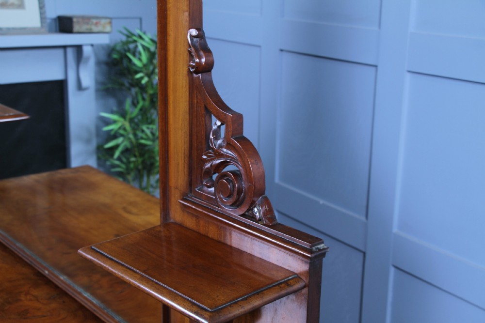 A Victorian mahogany mirror-back sideboard featuring two panelled cabinet doors, upper drawers, tiered side shelves, and a decorative carved cresting. View XV