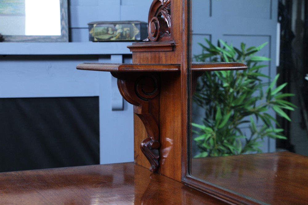 A Victorian mahogany mirror-back sideboard featuring two panelled cabinet doors, upper drawers, tiered side shelves, and a decorative carved cresting. View XVI