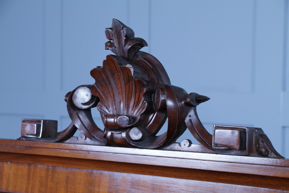 A Victorian mahogany mirror-back sideboard featuring two panelled cabinet doors, upper drawers, tiered side shelves, and a decorative carved cresting. View XVIII