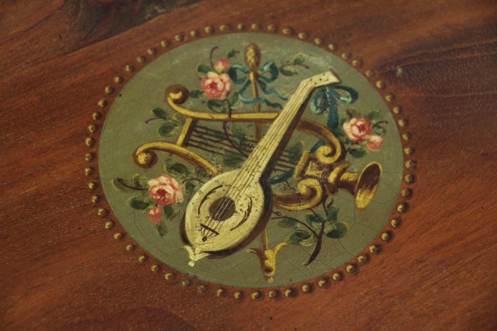 An Edwardian mahogany circular occasional table featuring a painted floral garland rim, central medallion, slender tapered legs, and an X-shaped cross-stretcher with a finial. View VI
