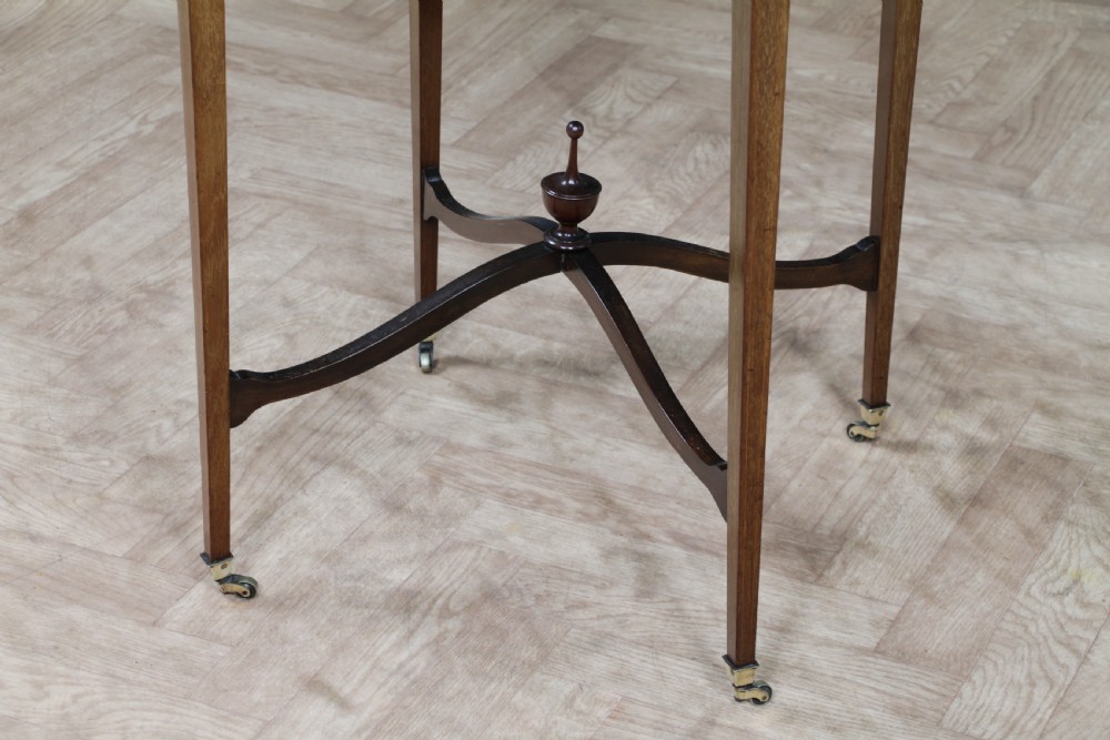 An Edwardian mahogany circular occasional table featuring a painted floral garland rim, central medallion, slender tapered legs, and an X-shaped cross-stretcher with a finial. View XI