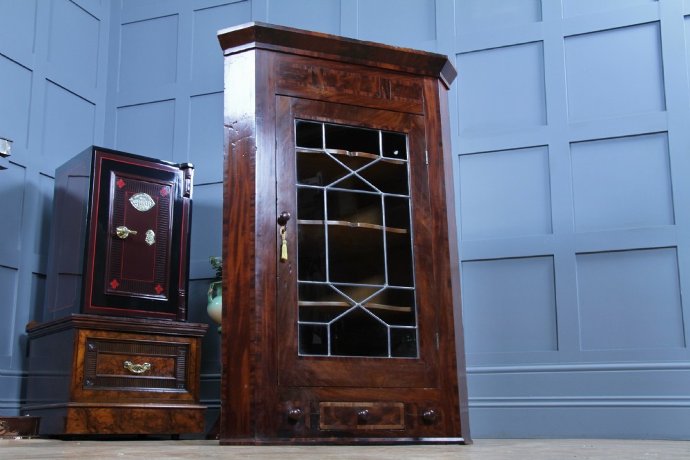 A Georgian mahogany wall-hanging corner cabinet featuring a single door with geometric glazed panels and a small base drawer. View V