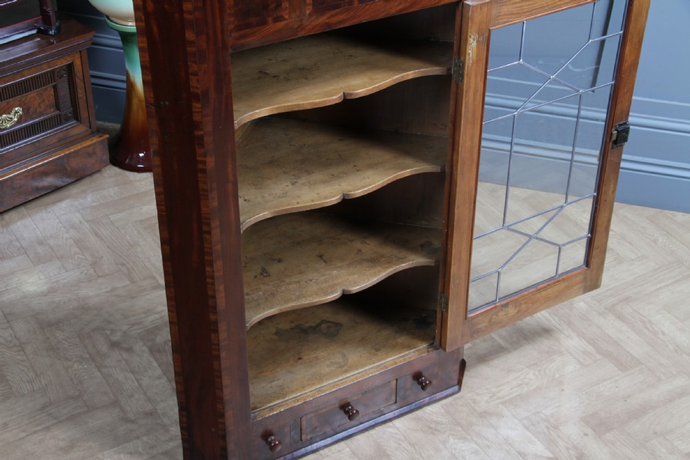 A Georgian mahogany wall-hanging corner cabinet featuring a single door with geometric glazed panels and a small base drawer. View XII