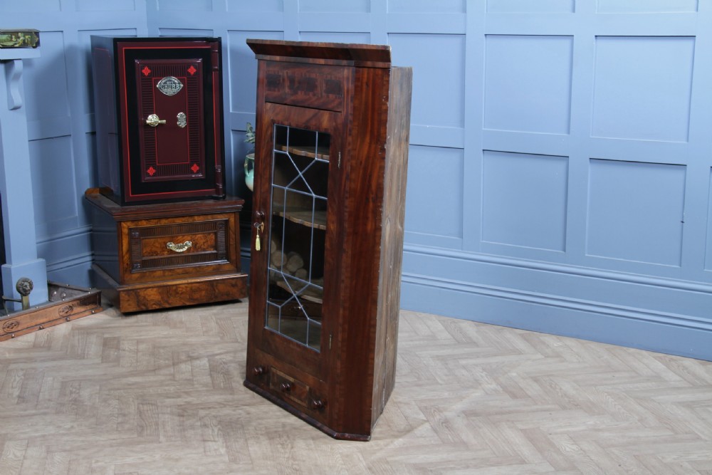 A Georgian mahogany wall-hanging corner cabinet featuring a single door with geometric glazed panels and a small base drawer. View XIV