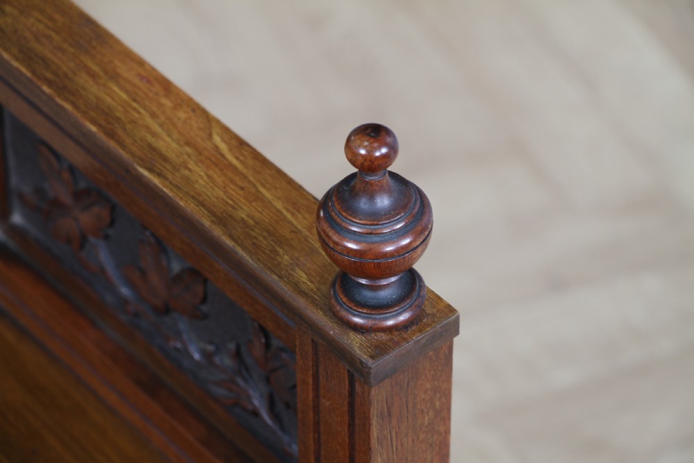 An Edwardian wall-mounted wooden cabinet featuring top finials, a carved floral panel, a central mirror, a lower drawer box with a brass handle, and bottom key hooks. View XIX