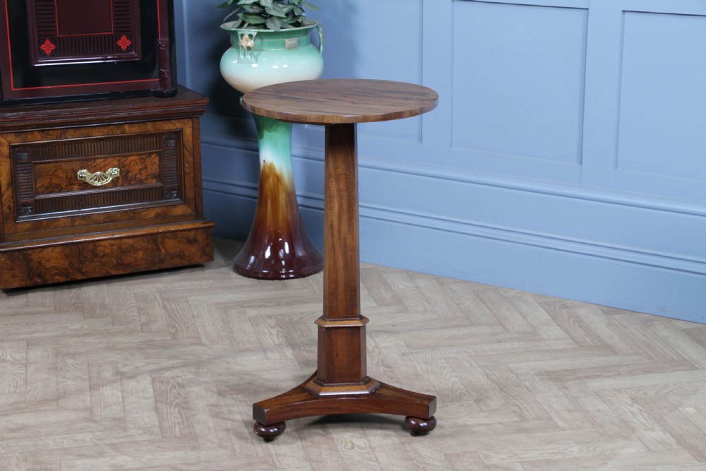 An antique William IV mahogany wine table featuring a circular top supported by a tapered faceted column and a triform base with bun feet. View VIII