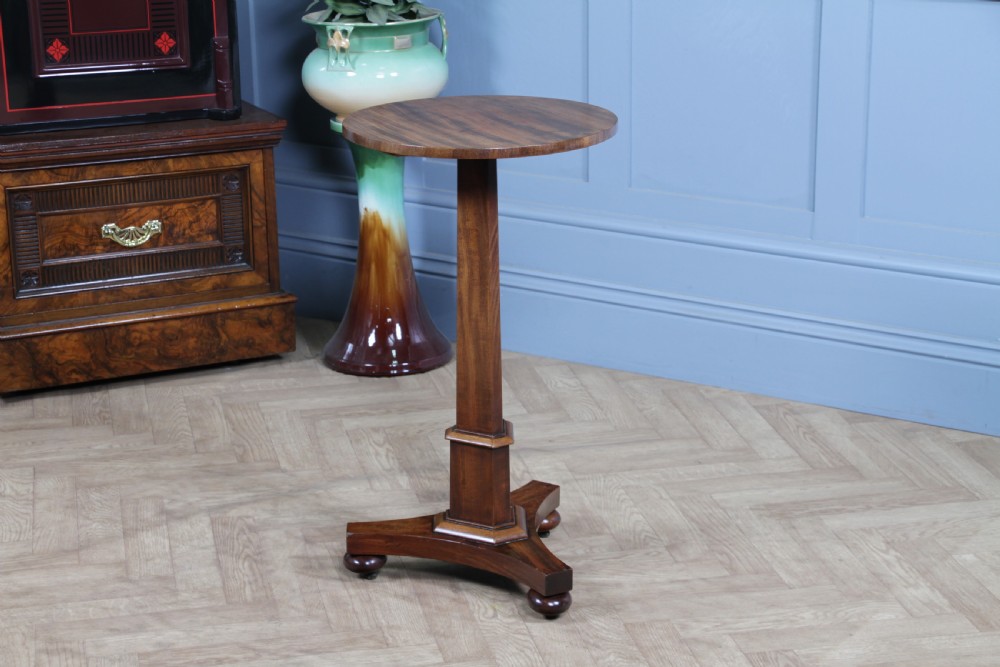 An antique William IV mahogany wine table featuring a circular top supported by a tapered faceted column and a triform base with bun feet. View IX