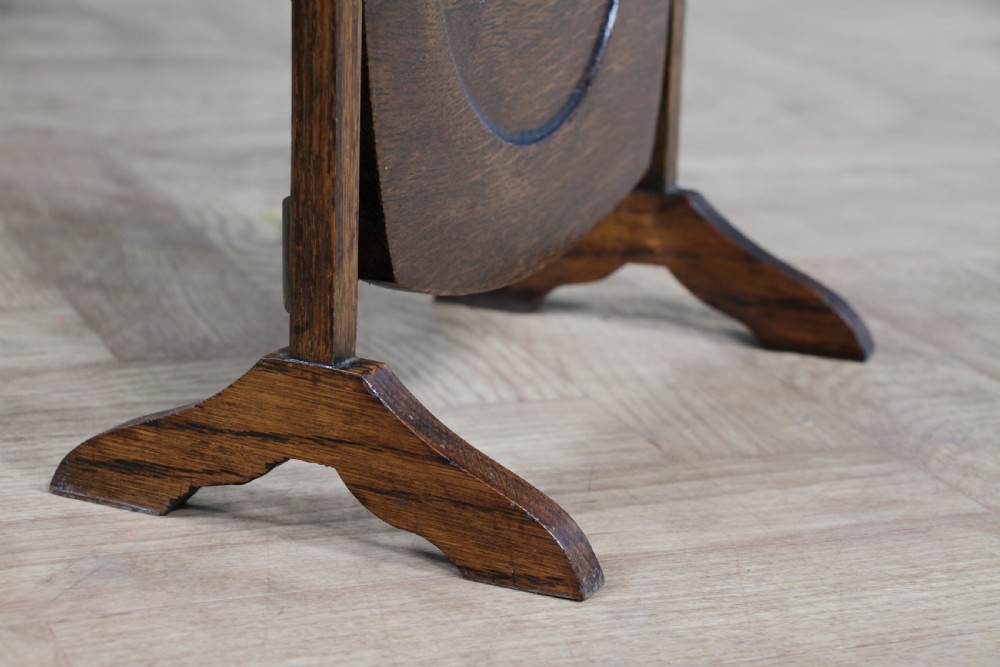 An Edwardian solid oak three-tier folding cake stand featuring square tiered shelves with recessed circular plate holders and an arched top handle. View VI