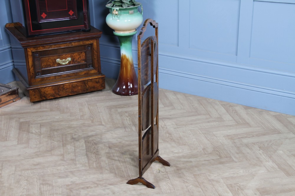 An Edwardian solid oak three-tier folding cake stand featuring square tiered shelves with recessed circular plate holders and an arched top handle. View IX