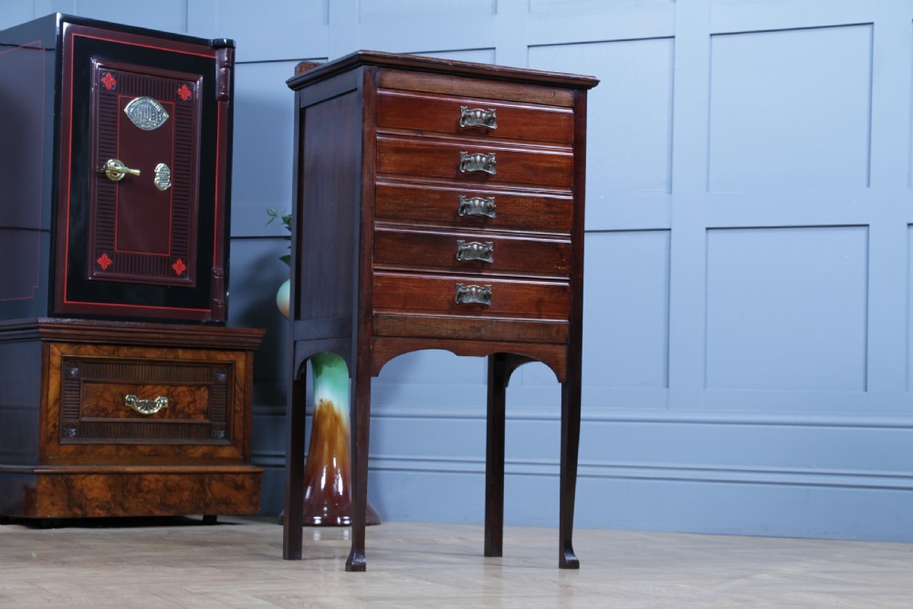 An Edwardian mahogany sheet music cabinet featuring five drop-front drawers fitted with Art Nouveau brass handles set on slender square legs. View II
