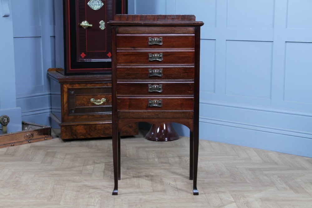 An Edwardian mahogany sheet music cabinet featuring five drop-front drawers fitted with Art Nouveau brass handles set on slender square legs. View III