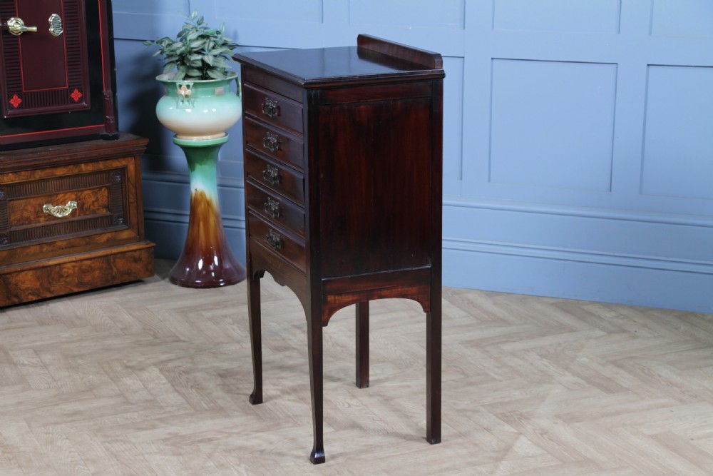 An Edwardian mahogany sheet music cabinet featuring five drop-front drawers fitted with Art Nouveau brass handles set on slender square legs. View XI