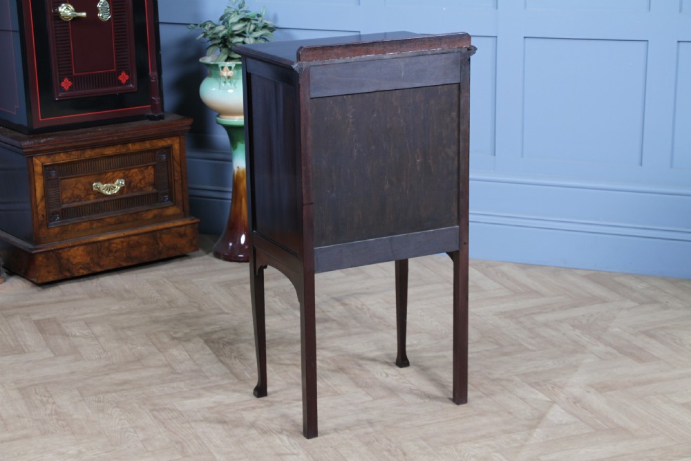 An Edwardian mahogany sheet music cabinet featuring five drop-front drawers fitted with Art Nouveau brass handles set on slender square legs. View XIII