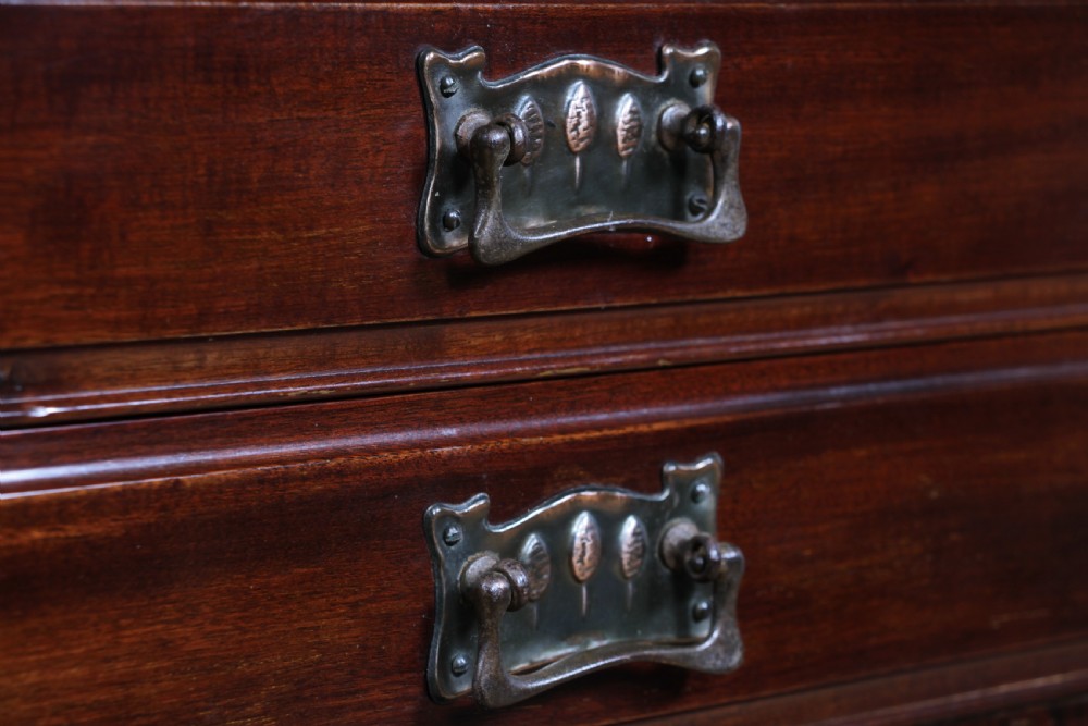 An Edwardian mahogany sheet music cabinet featuring five drop-front drawers fitted with Art Nouveau brass handles set on slender square legs. View XIV