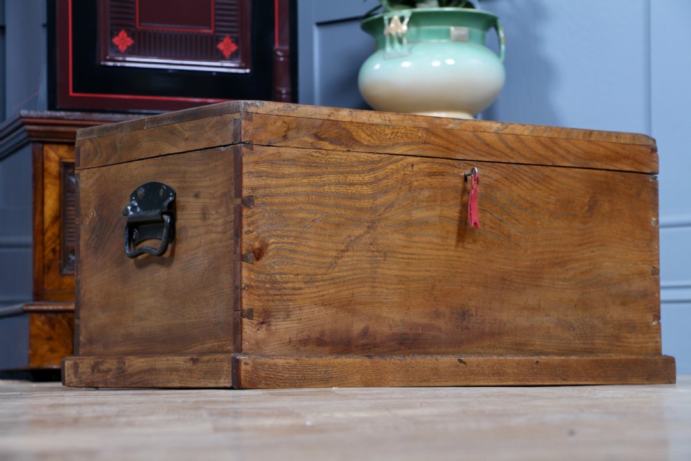 A rectangular solid elm tool chest featuring hand-cut dovetail joints, black iron side handles, and a warm wood grain finish. View II
