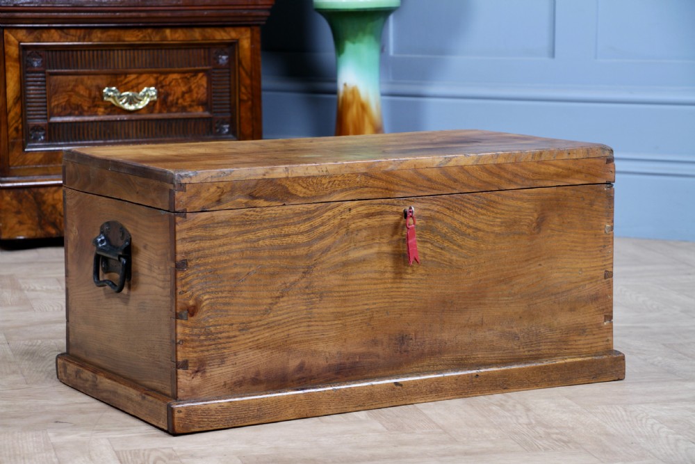 A rectangular solid elm tool chest featuring hand-cut dovetail joints, black iron side handles, and a warm wood grain finish. View III