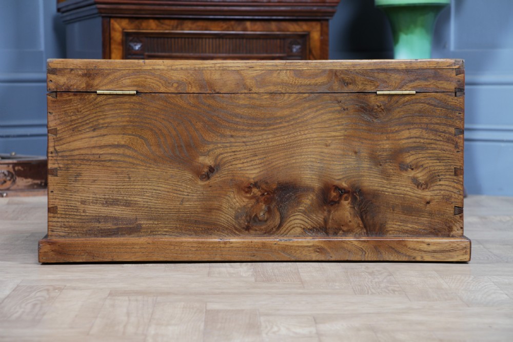 A rectangular solid elm tool chest featuring hand-cut dovetail joints, black iron side handles, and a warm wood grain finish. View XI