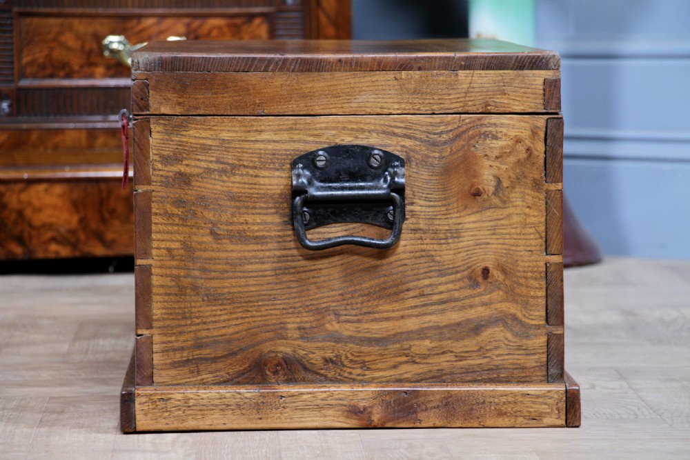 A rectangular solid elm tool chest featuring hand-cut dovetail joints, black iron side handles, and a warm wood grain finish. View XII