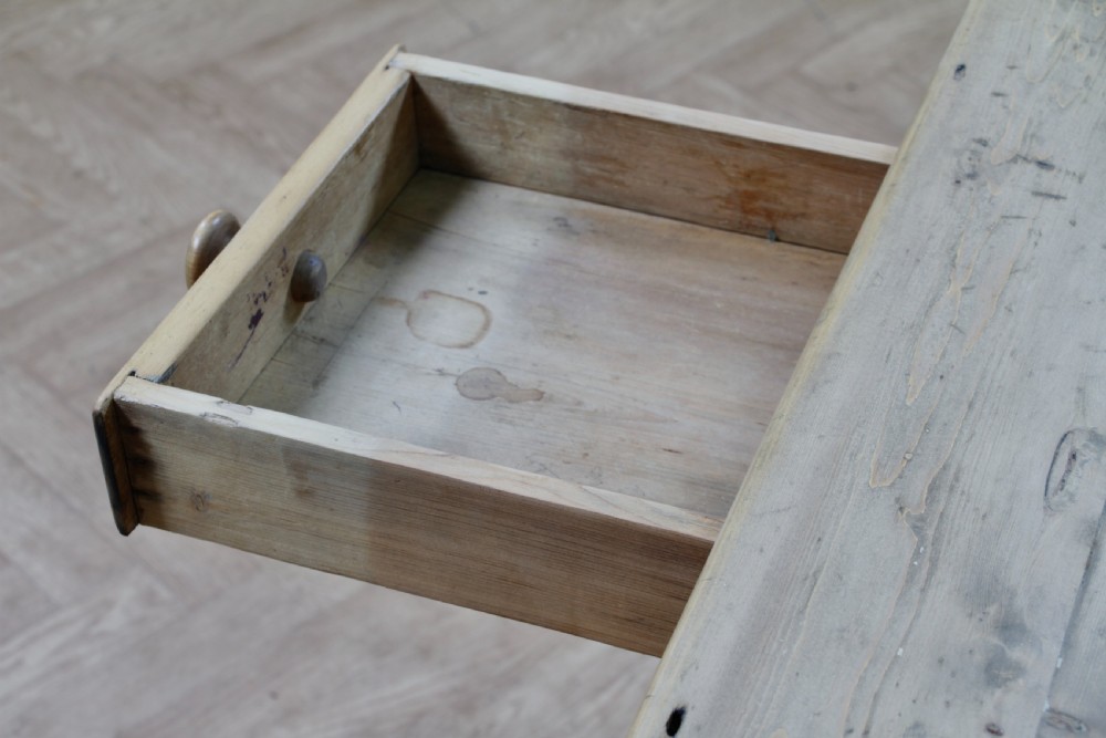 A restored Victorian pine kitchen table featuring a scrubbed rectangular plank top, a single frieze drawer with a wooden knob, and four turned legs. View X