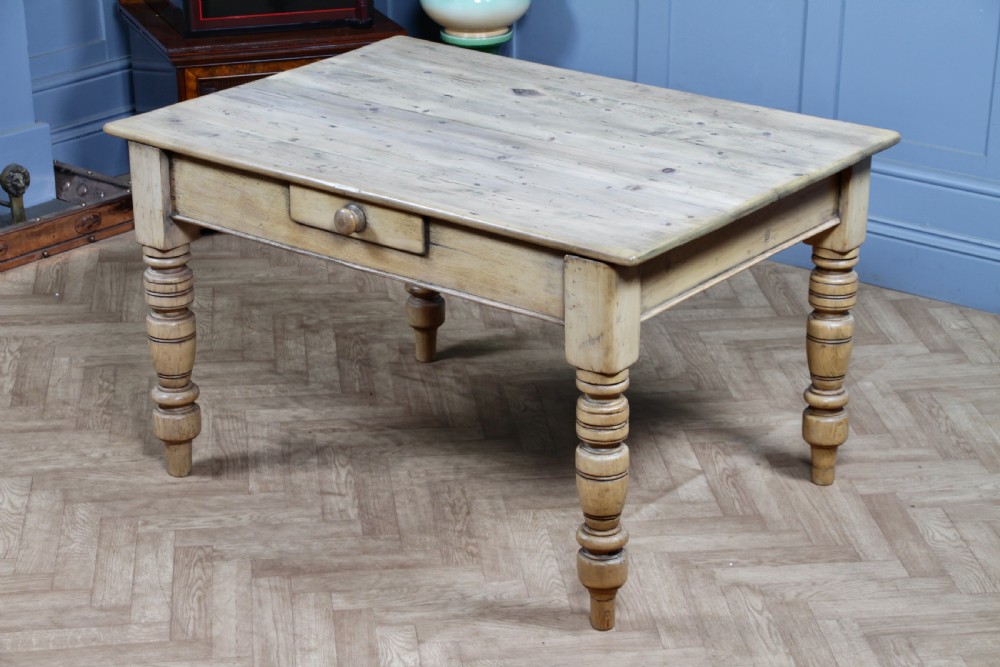 A restored Victorian pine kitchen table featuring a scrubbed rectangular plank top, a single frieze drawer with a wooden knob, and four turned legs. View XVI