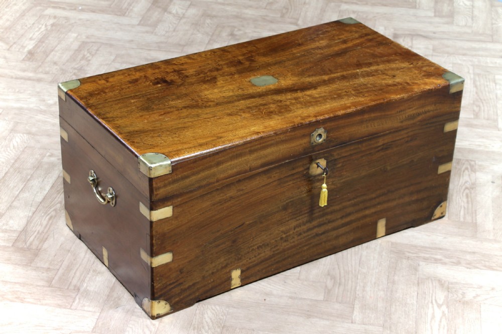 A rectangular Victorian camphor wood military campaign trunk featuring brass corner straps, side handles, and a central brass keyhole.