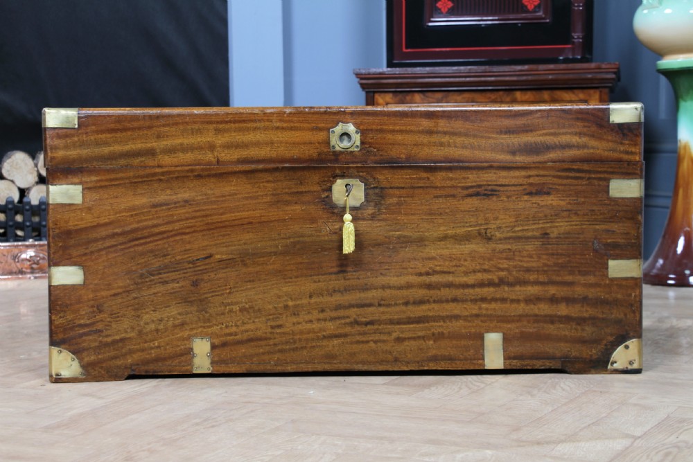 A rectangular Victorian camphor wood military campaign trunk featuring brass corner straps, side handles, and a central brass keyhole. View V