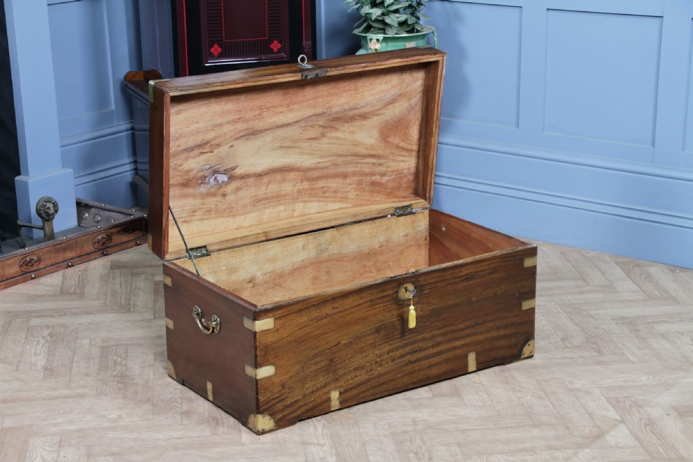 A rectangular Victorian camphor wood military campaign trunk featuring brass corner straps, side handles, and a central brass keyhole. View VII