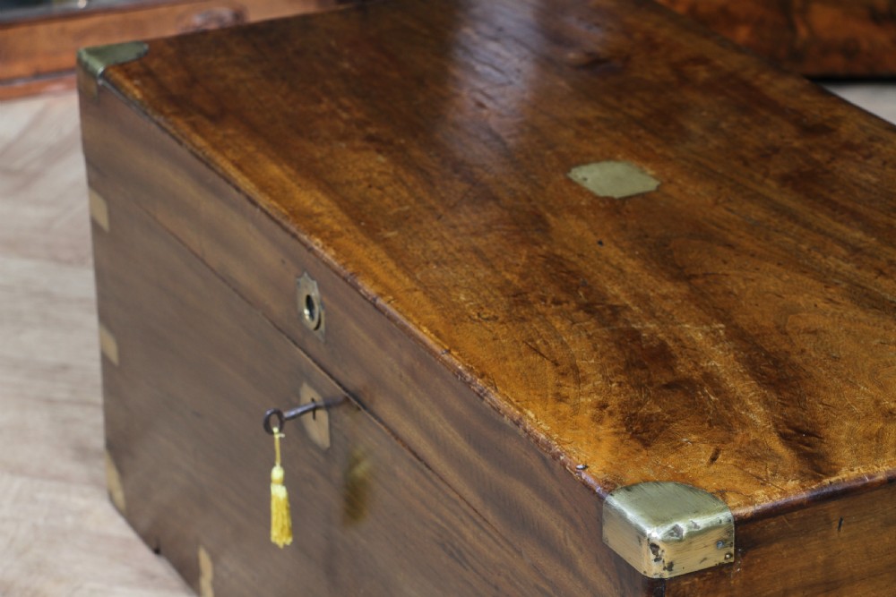 A rectangular Victorian camphor wood military campaign trunk featuring brass corner straps, side handles, and a central brass keyhole. View X