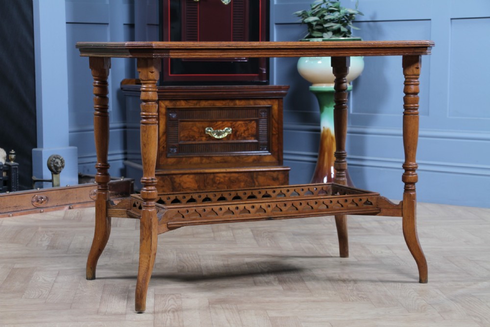 An Edwardian golden oak side table featuring a rectangular top, turned support legs, and a lower undertier shelf with a pierced cut-out gallery rail. View II